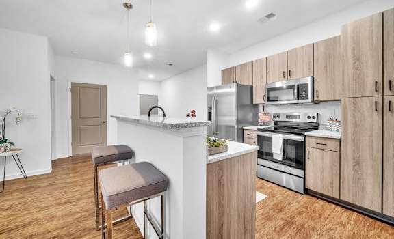 Kitchen with island and refrigerator at Fox Hunt Farms Fort Mill apartments