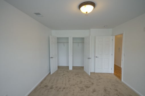 Bedroom with a double closet and carpet floors