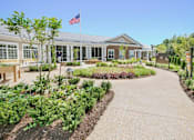 Thumbnail 1 of 5 - a garden in front of a building with an flag