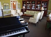 Thumbnail 3 of 6 - a living room with a piano in the center of it
