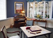 Thumbnail 3 of 5 - a small room with a table and a piano
