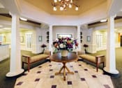 Thumbnail 1 of 5 - a lobby with a vase of flowers on a table