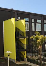 A modern building with a yellow accent on the side.