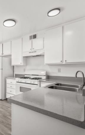 a kitchen with white cabinets and white appliances and a sliding glass door at Ocean Villas, California, 93033
