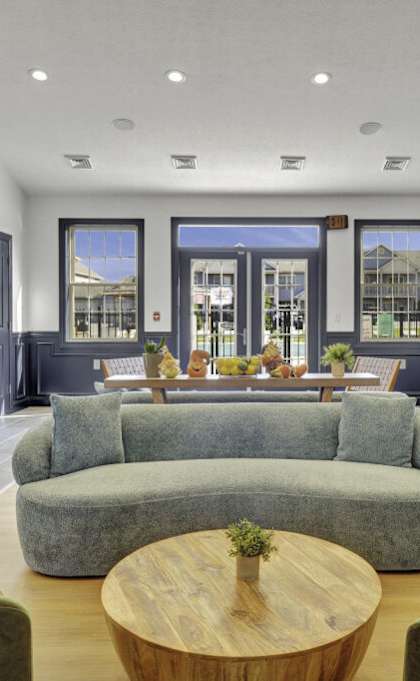 A modern living room with a large grey sofa and a wooden coffee table.
