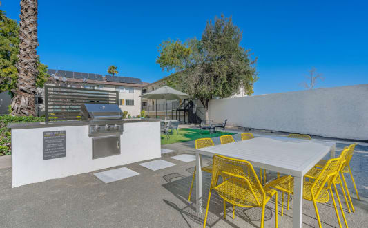 a patio with a table and chairs and a barbecue grill at The Hills Apartments at Thousand Oaks, California, 91360