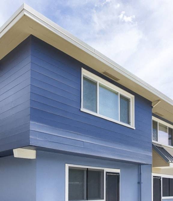 A blue house with white trim and windows.