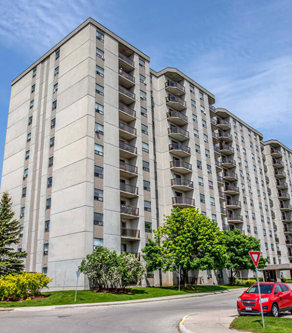 a picture of an apartment building with cars parked in front of it