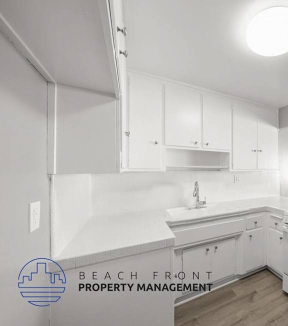 A well-lit bedroom with a large bed and a painting on the wall.