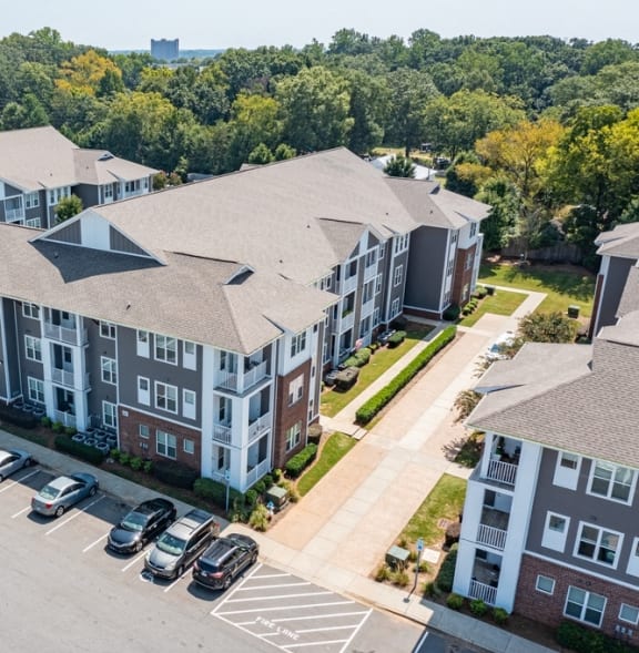 an aerial view of an apartment complex with cars parked in a parking lot