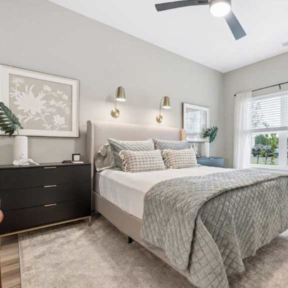 A bedroom with a bed, nightstands, and a window.