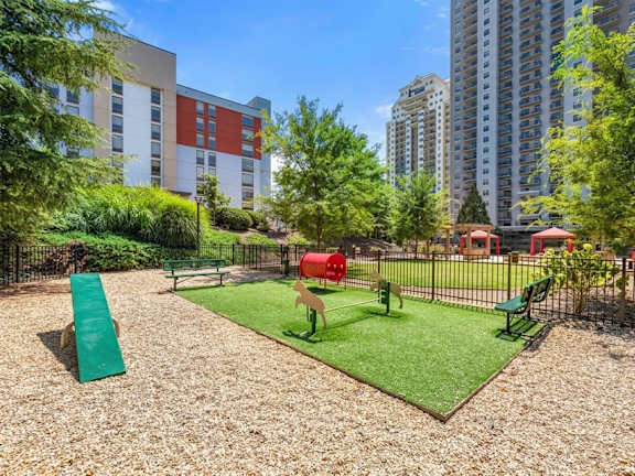 A playground with a green slide and a red slide.