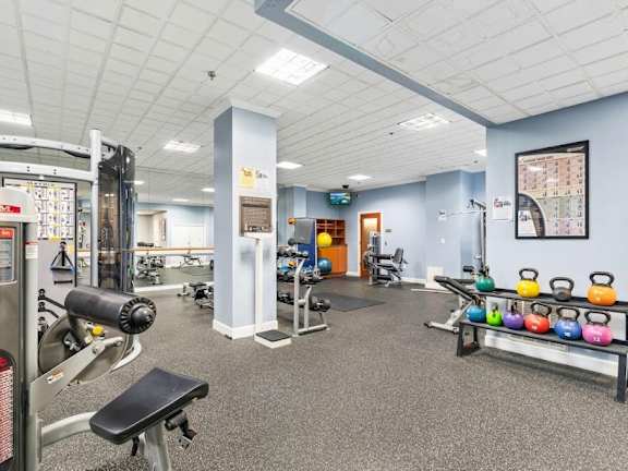 A gym with a variety of equipment including weights and machines.