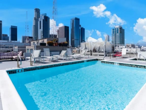 a rooftop pool with a city skyline in the background