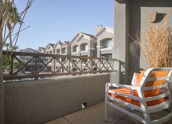 model balcony with views of the community and an orange chair