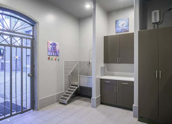 Pet Wash Station with white floors, brown cabinets and door to outside