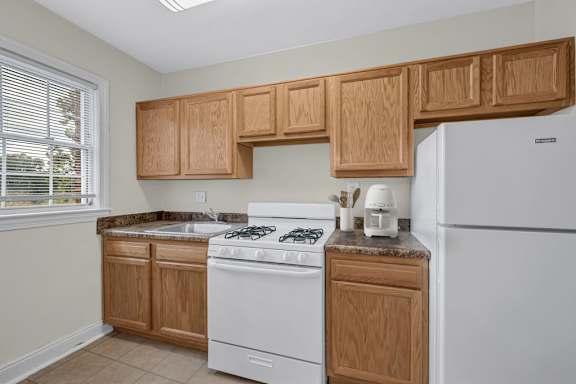 A kitchen with a black countertop and white cabinets.