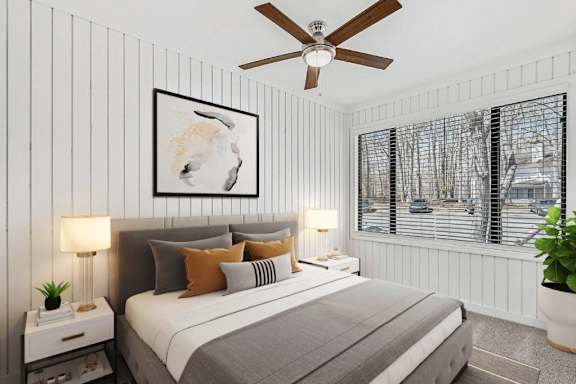 A bedroom with a bed, nightstands, and a ceiling fan. at Woodlyn on the Green Apartment Homes, Cary