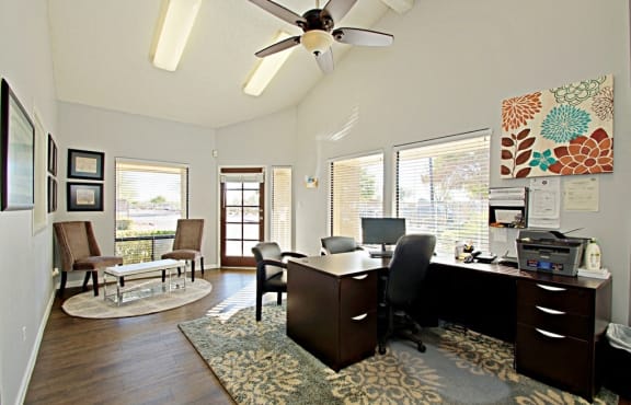 a home office with a desk and a ceiling fan