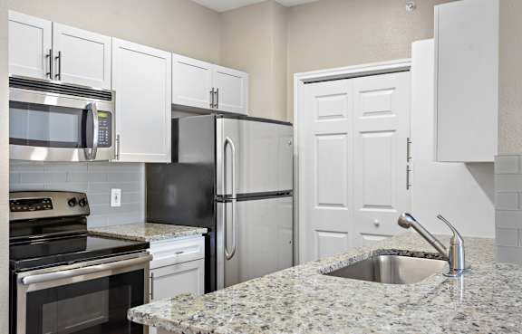a kitchen with granite counter tops and stainless steel appliances