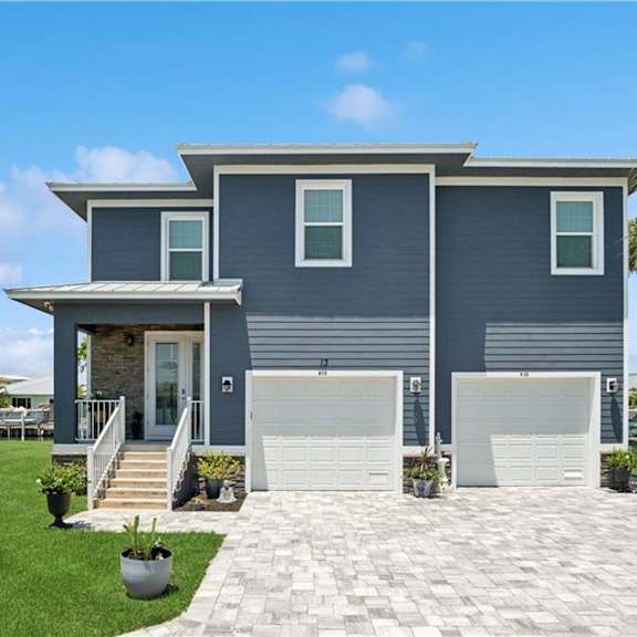 A modern house with a grey exterior and a white garage door.