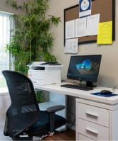 a desk with a computer and a chair in an office at Quail Run Apartments, Vancouver, WA 98684