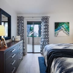 a bedroom with a bed and a door to a balcony at The Bryant Apartments at Yorba Linda, Yorba Linda California