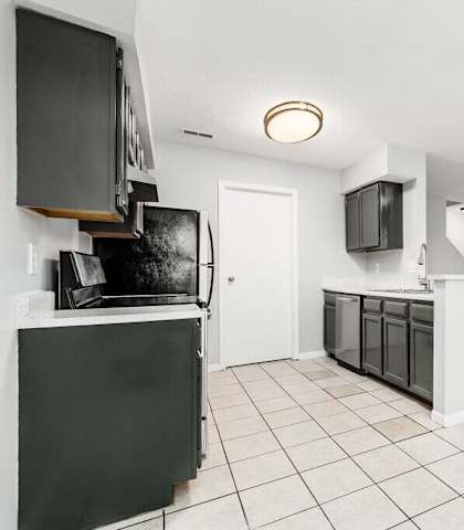 A kitchen with black appliances and white cabinets.