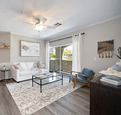 A living room with a white couch, a coffee table, and a ceiling fan.