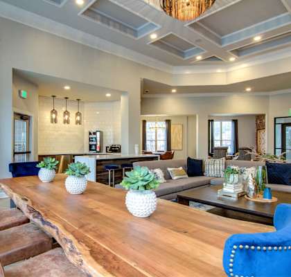 a living room with a long wooden table and blue chairs