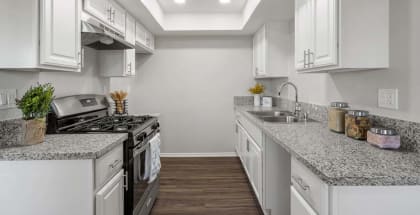 a kitchen with a stove top oven next to a sink at Aspire Redlands, Redlands California