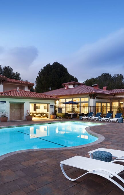 a swimming pool in front of a hotel at dusk at The Bryant Apartments at Yorba Linda, Yorba Linda California
