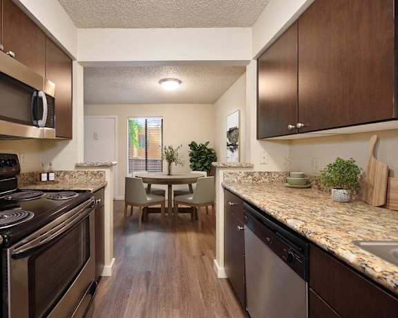 full kitchen with stainless steel appliances and granite counter tops and a dining room table