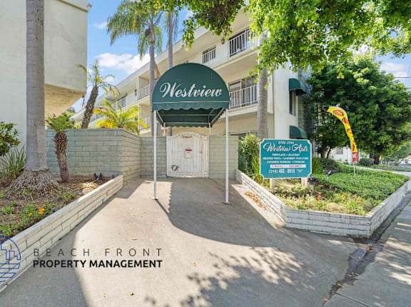 The entrance to a building named Westview with a sign for Beach Front Property Management.