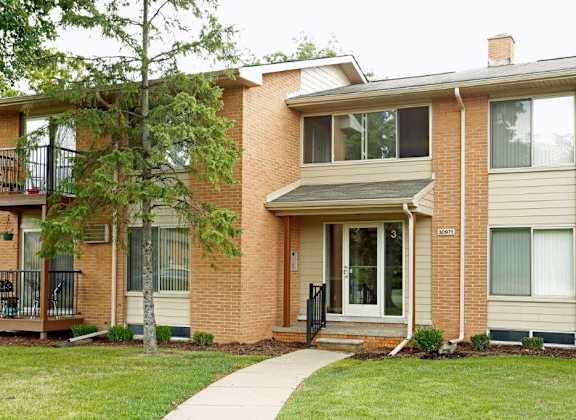 a brick house with a sidewalk in front of it