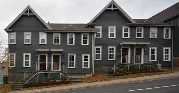a large gray house on the side of a street