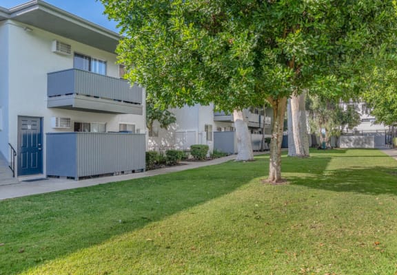 an apartment building with a lawn and trees in front of it at BLVD Apartments LLC, California
