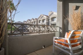model balcony with views of the community and an orange chair