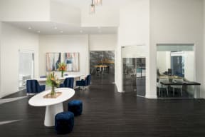 The Highland Leasing Office with dark floors, white table and navy chairs
