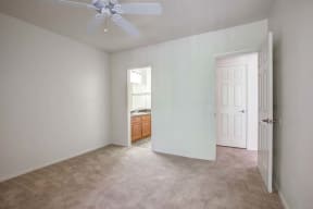 The Palms Apartments Bedroom with wall to wall carpet and ceiling fan
