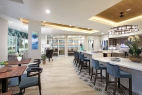 Restaurant interior featuring a bar and tables with chairs for dining