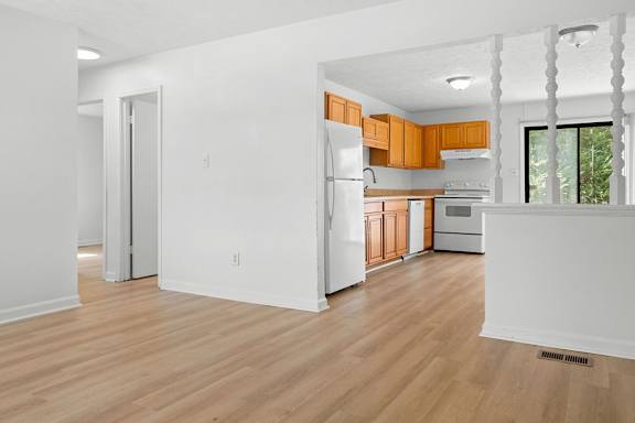 A kitchen with wooden floors and white walls.