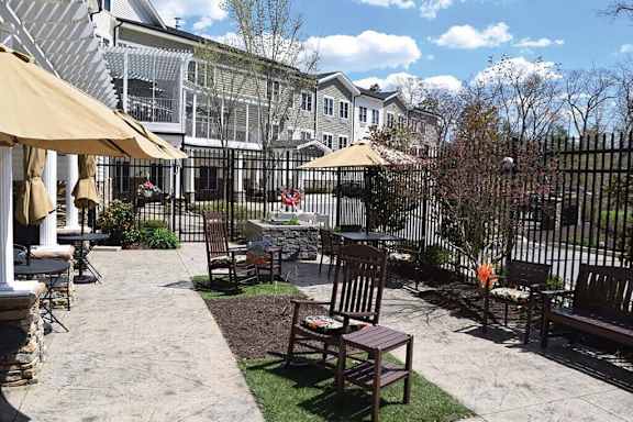 a patio with chairs and umbrellas in front of a house