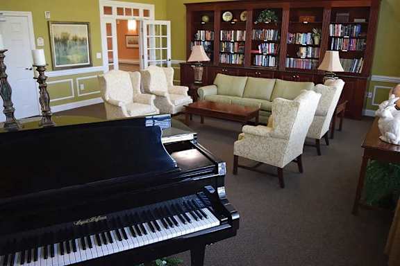 a living room with a piano in the center of it