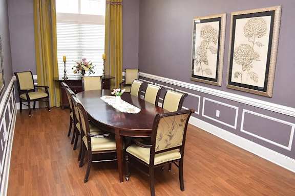 a dining room with a wooden table and chairs