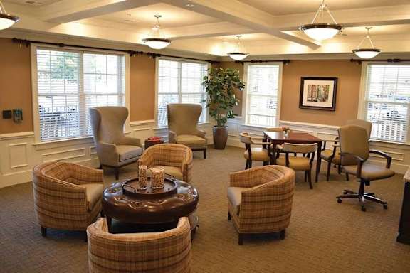 a living room filled with chairs and a table