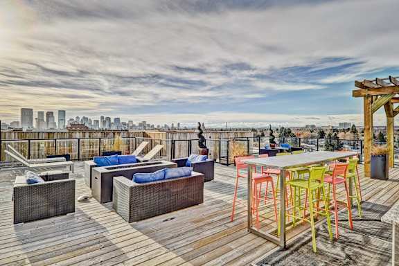 A wooden deck with a table and chairs overlooking a city skyline.