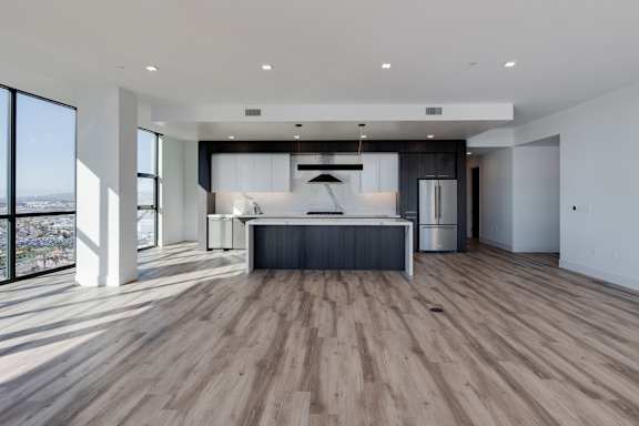 A modern kitchen with a large island and a view of the city.