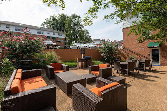 A patio with orange couches and chairs. at Park Georgetown Apartments, Arlington, VA, 22209