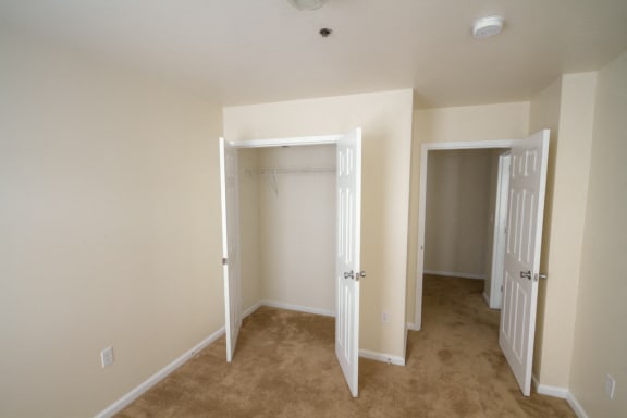 Bedroom with carpeted floor and double door closet